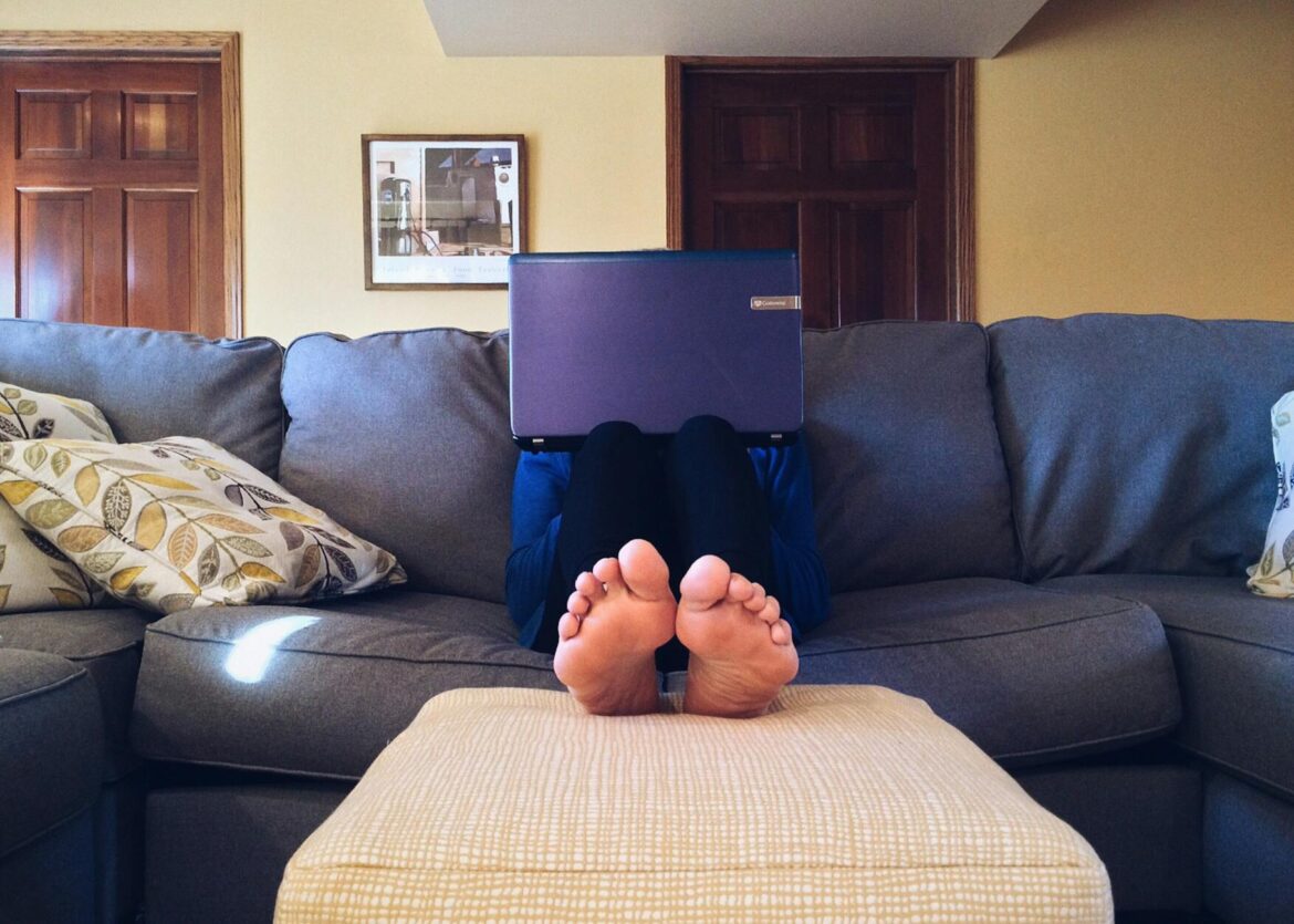 pexels-photo-269129 person sitting on couch while using laptop computer
