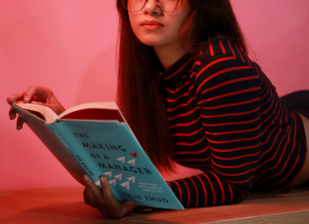 pexels-photo-4581325 woman in striped long sleeve shirt holding a book