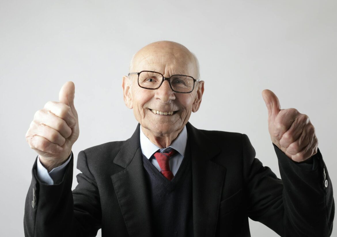 pexels-photo-3824771 positive senior man in eyeglasses showing thumbs up and looking at camera