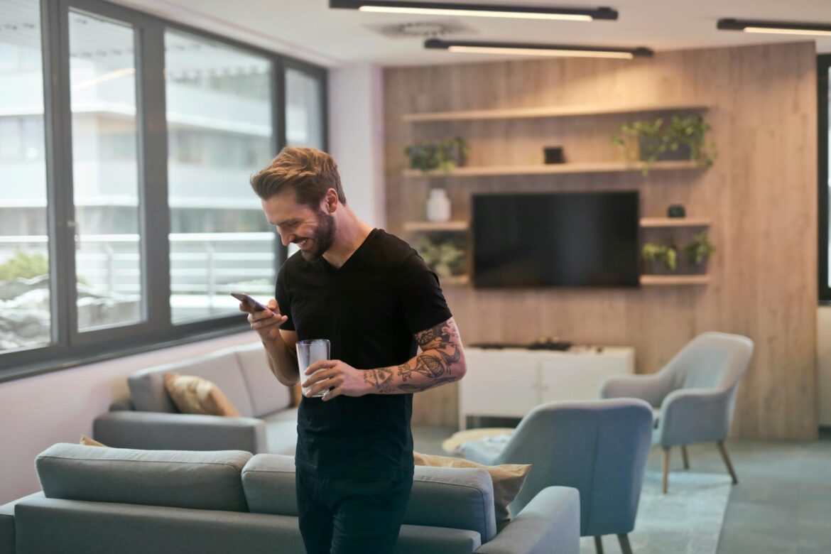 man in black shirt standing while holding drinking glass